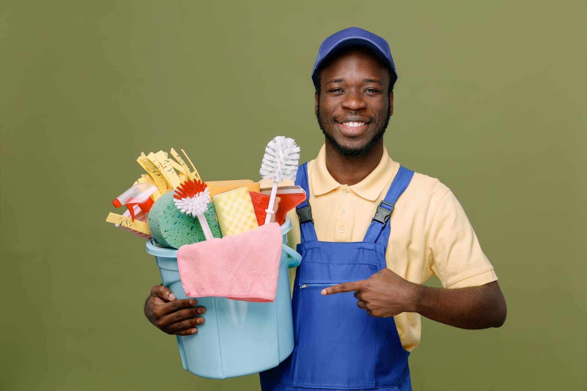 A man is holding a bucket of cleaning supplies and pointing at it.