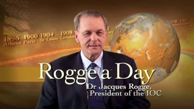 A man in a suit and tie is standing in front of a globe and the words