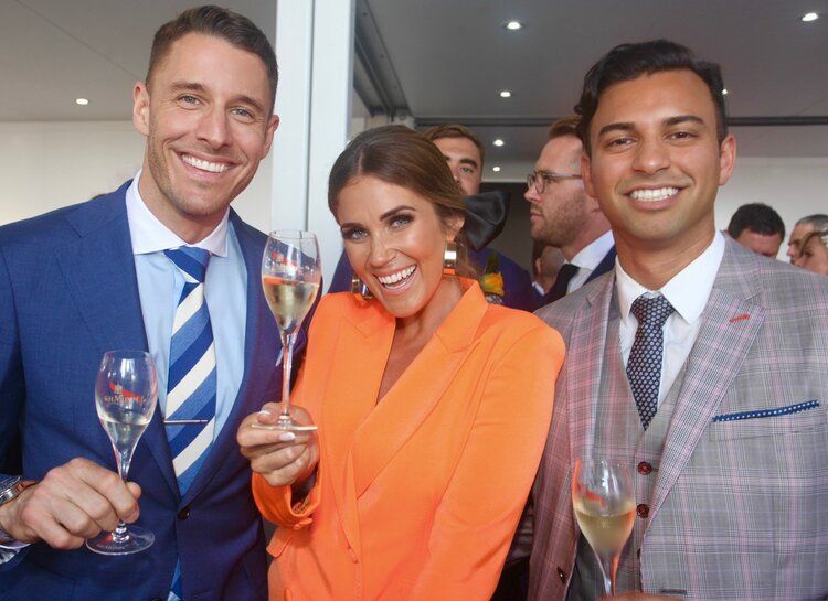 A group of people are standing next to each other holding champagne glasses.