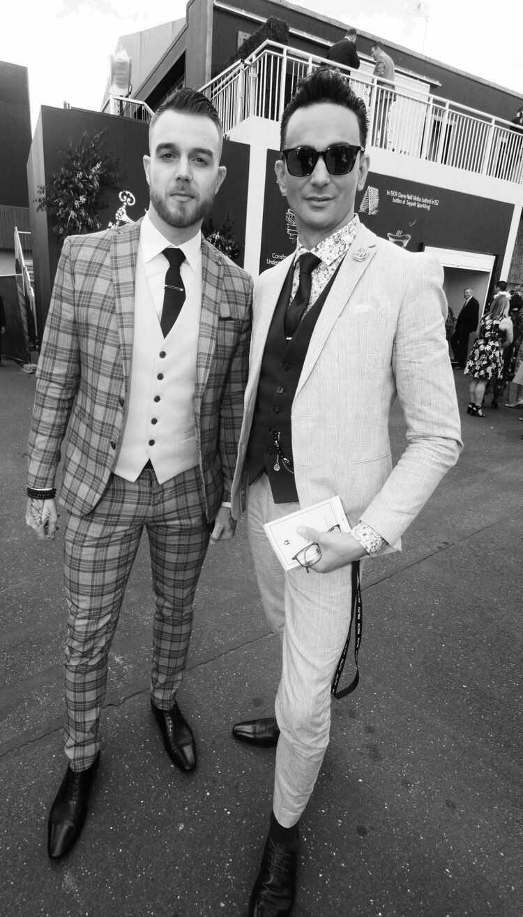 Two men in suits and ties are standing next to each other in a black and white photo.