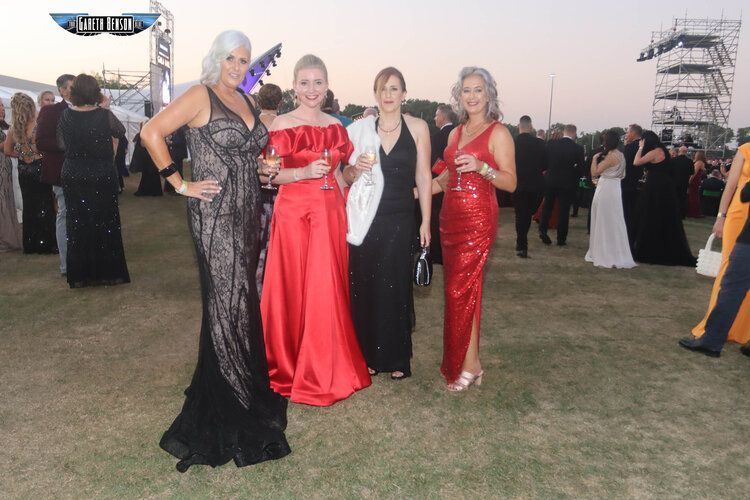 A group of women are posing for a picture in a field