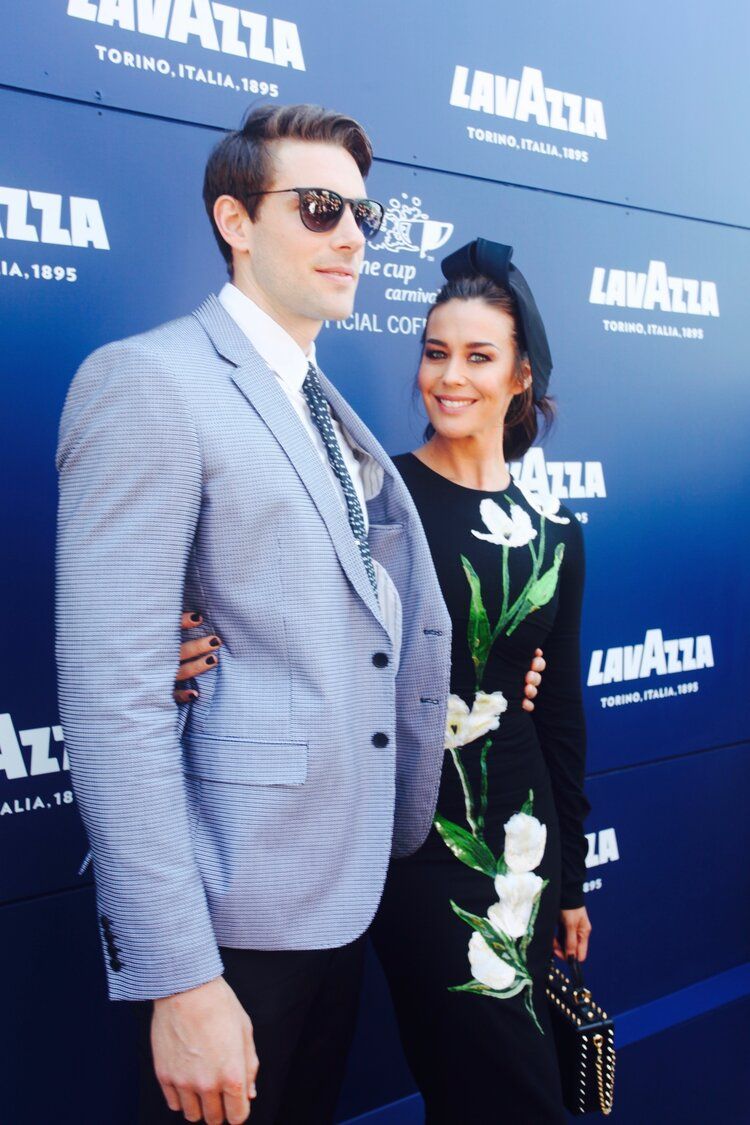 A man and woman standing in front of a lavazza sign