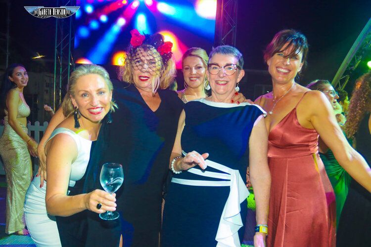 A group of women are posing for a picture at a party.