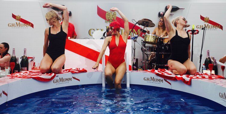 A group of women in swimsuits are sitting in a pool of water.