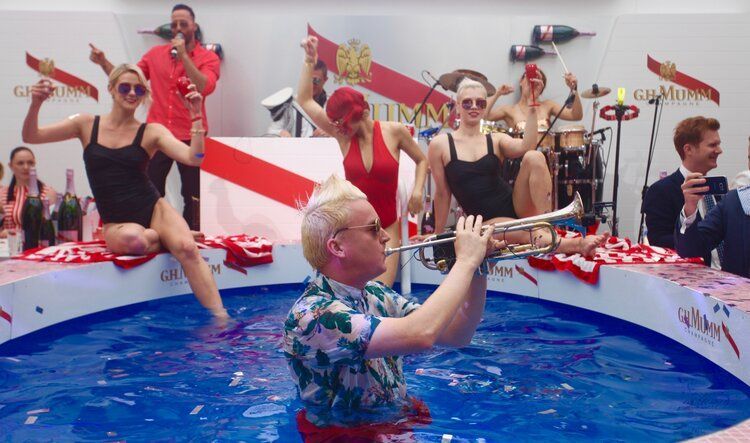 A man is playing a trumpet in a pool of water.