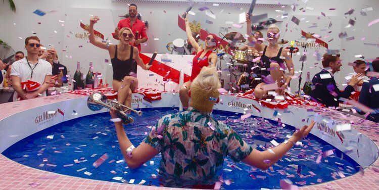 A woman is standing in a pool of water holding a trumpet.
