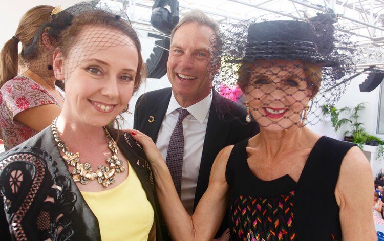 A man and two women are posing for a picture together.
