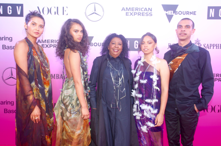 A group of people posing for a picture on a pink carpet