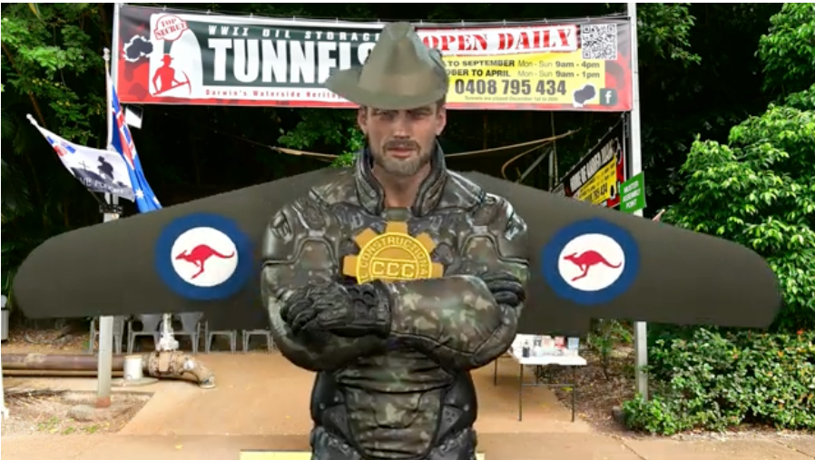 A man in a military uniform is standing in front of a tunnelfit sign.