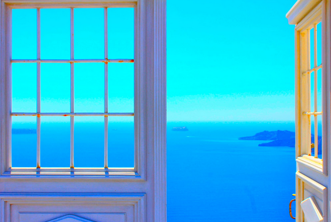 A view of the ocean through a window with bars.