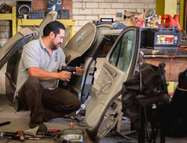 Person Working On Car Door — Houston, TX — Lonestar Imports