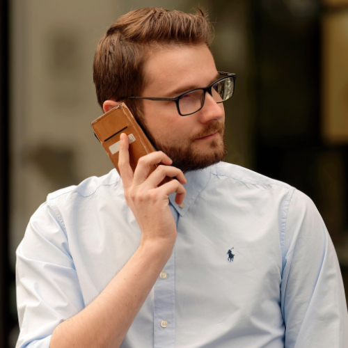 A man wearing glasses is talking on a cell phone