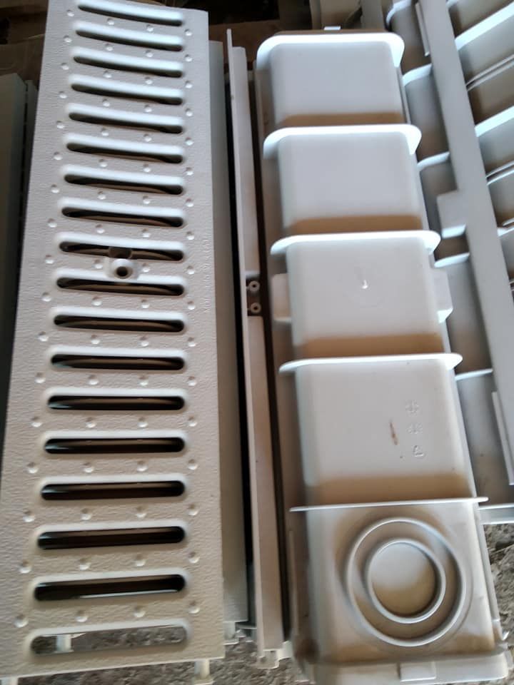 Parti in plastica grigia per canalette di drenaggio: griglia, corpo del canale e pezzi aggiuntivi.