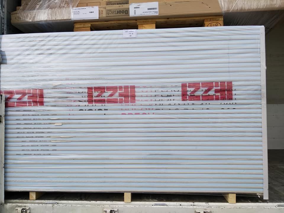 Pallet di pannelli bianchi avvolti con loghi rossi 