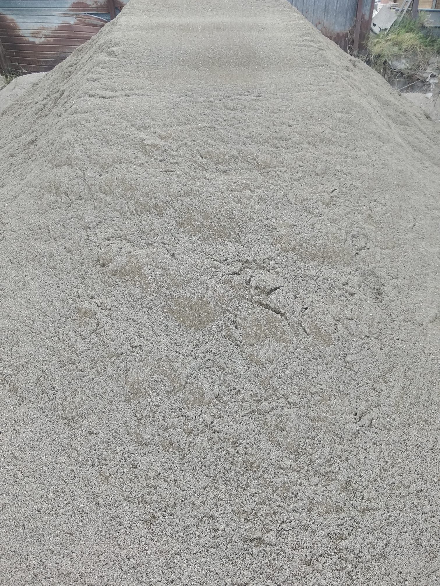 Mucchio di ghiaia chiara, possibilmente sabbia, all'aperto.