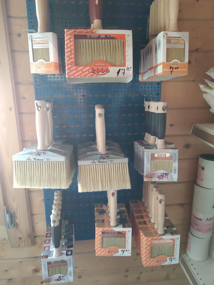 Esposizione di pennelli su un pannello forato blu in un negozio.