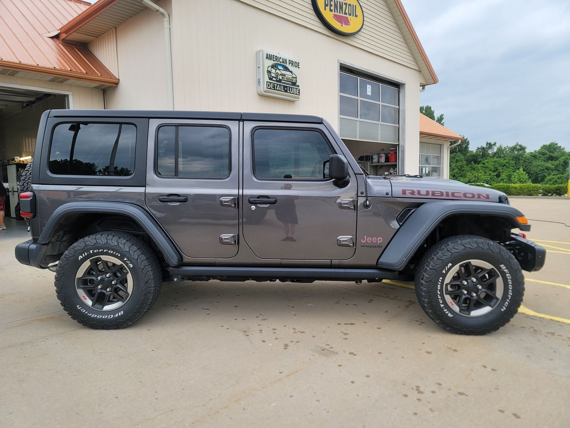 Gray Jeep Rubicon parked outside a building.