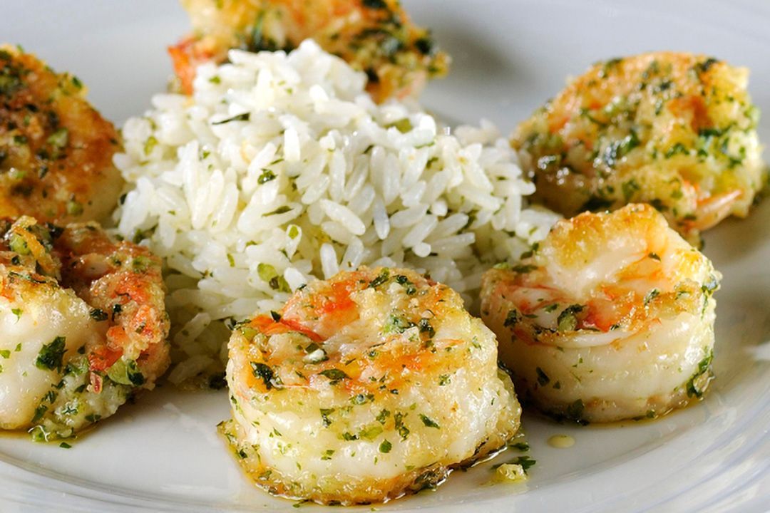 Imagem de camarões grelhados ao alho e óleo, dourados e suculentos, finalizados com salsinha fresca. Um prato clássico e irresistível da gastronomia brasileira, perfeito para ilustrar receitas práticas com frutos do mar no site da IE Pescados. Camarão Alho e Óleo IE Pescados - receita simples de frutos do mar