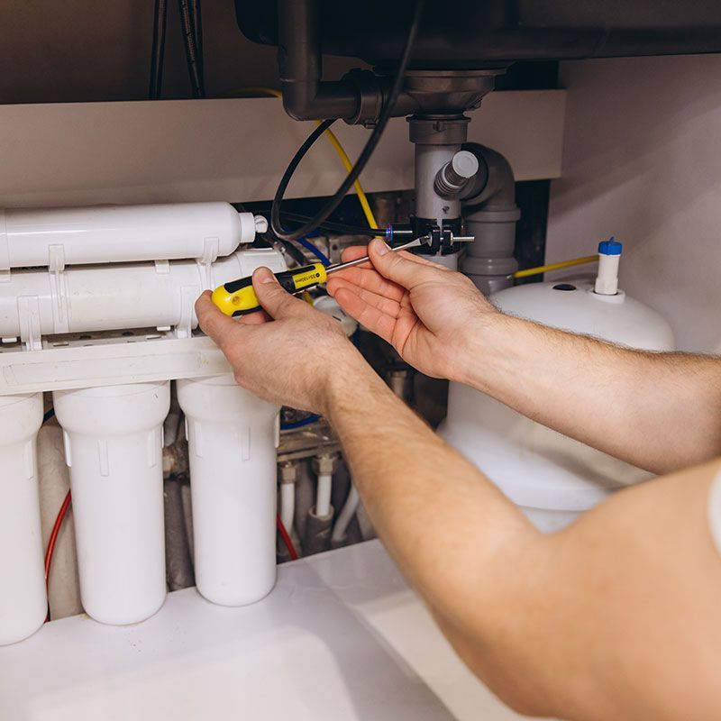 Plumber Installing Water Filter System Under Kitchen Sink