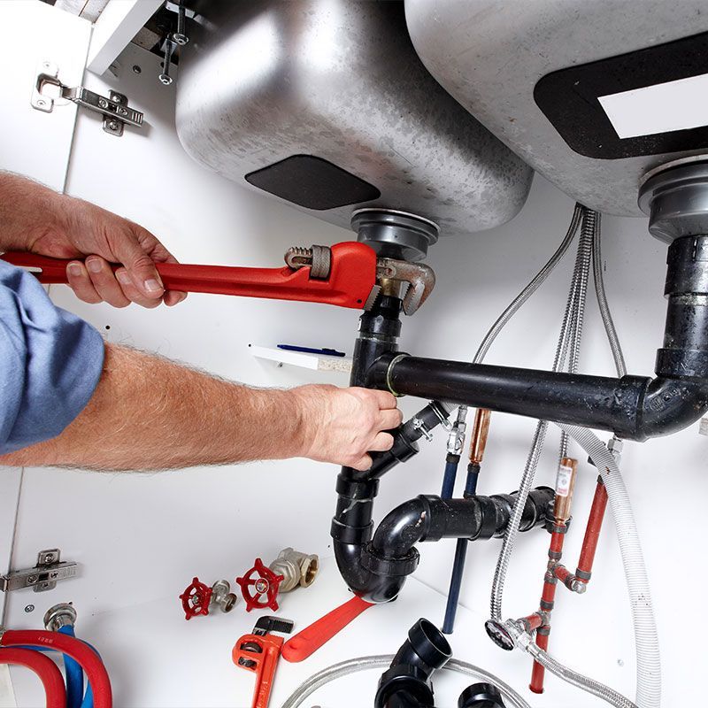 Hands of Plumber with a wrench