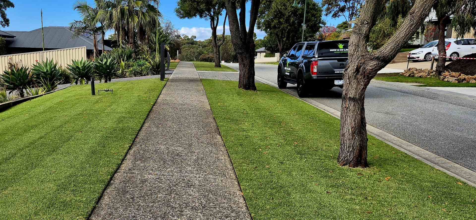 A truck is parked on the side of the road next to a sidewalk.