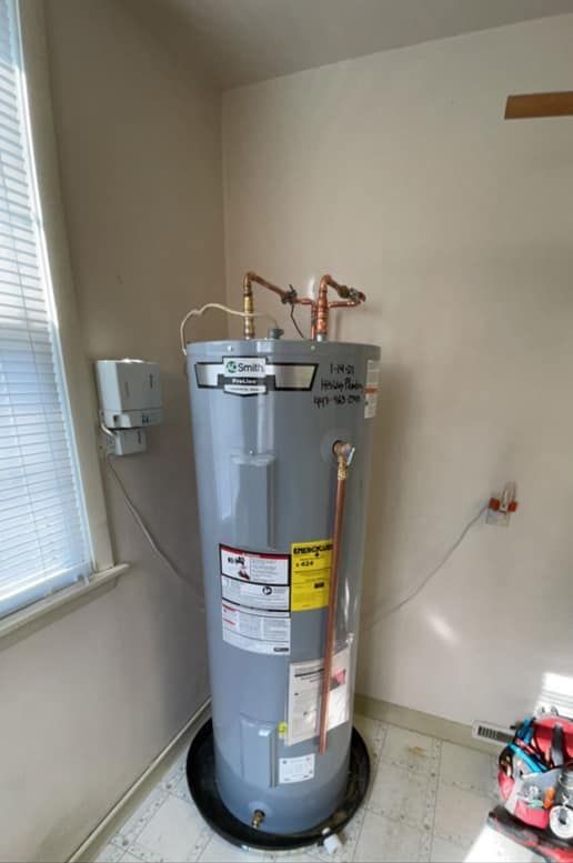 A water heater is sitting in a room next to a window.