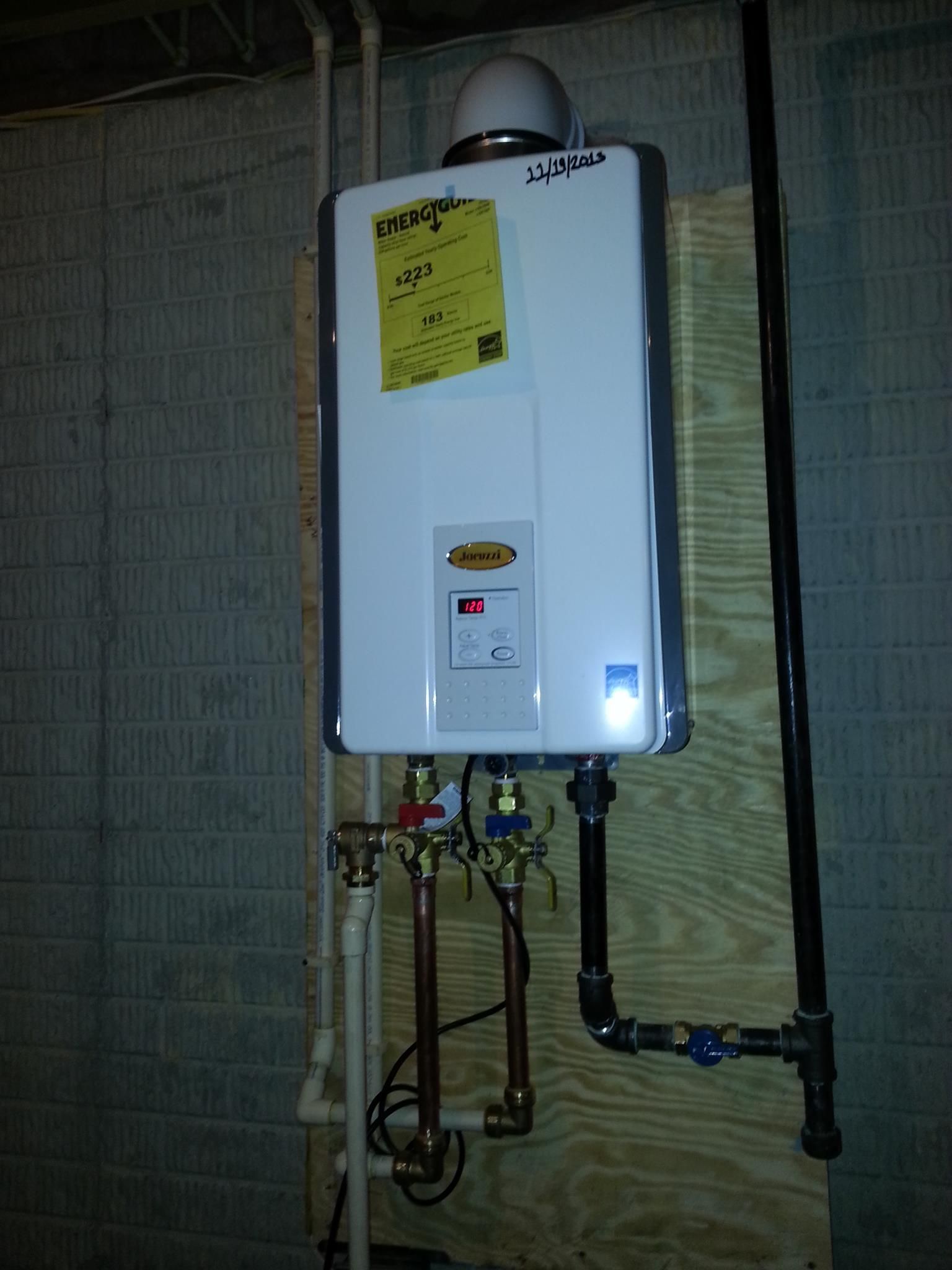 A white water heater is mounted on a wall next to pipes.