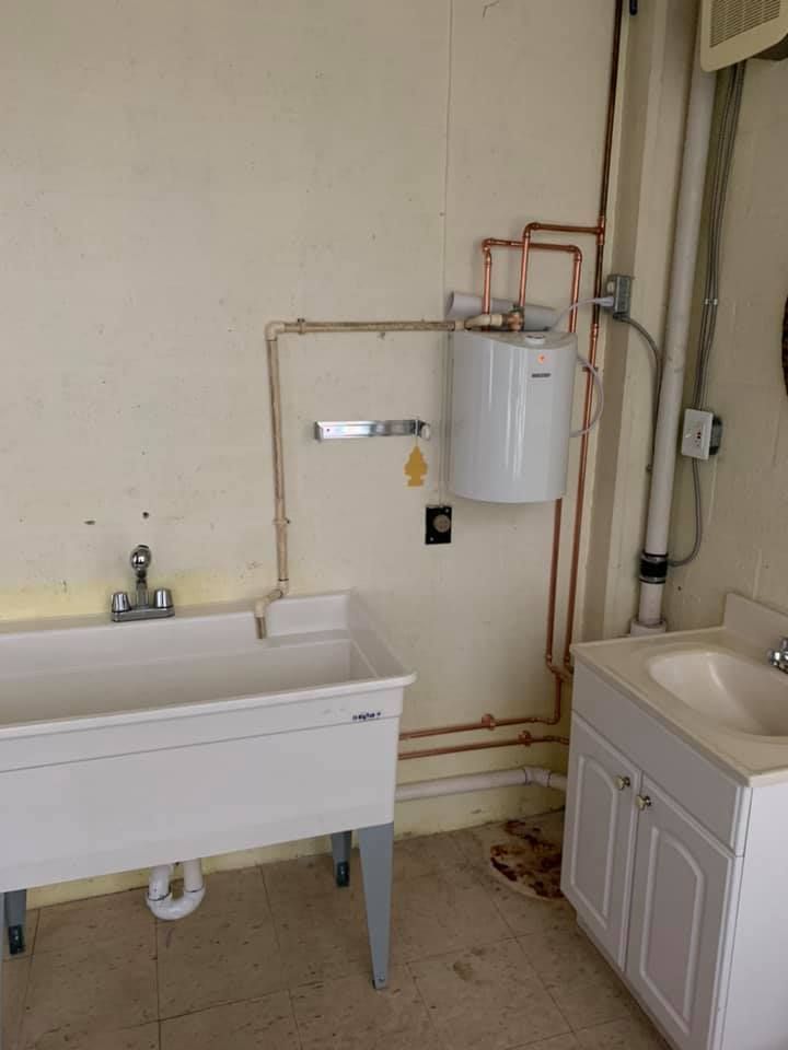 A laundry room with a sink and a water heater.