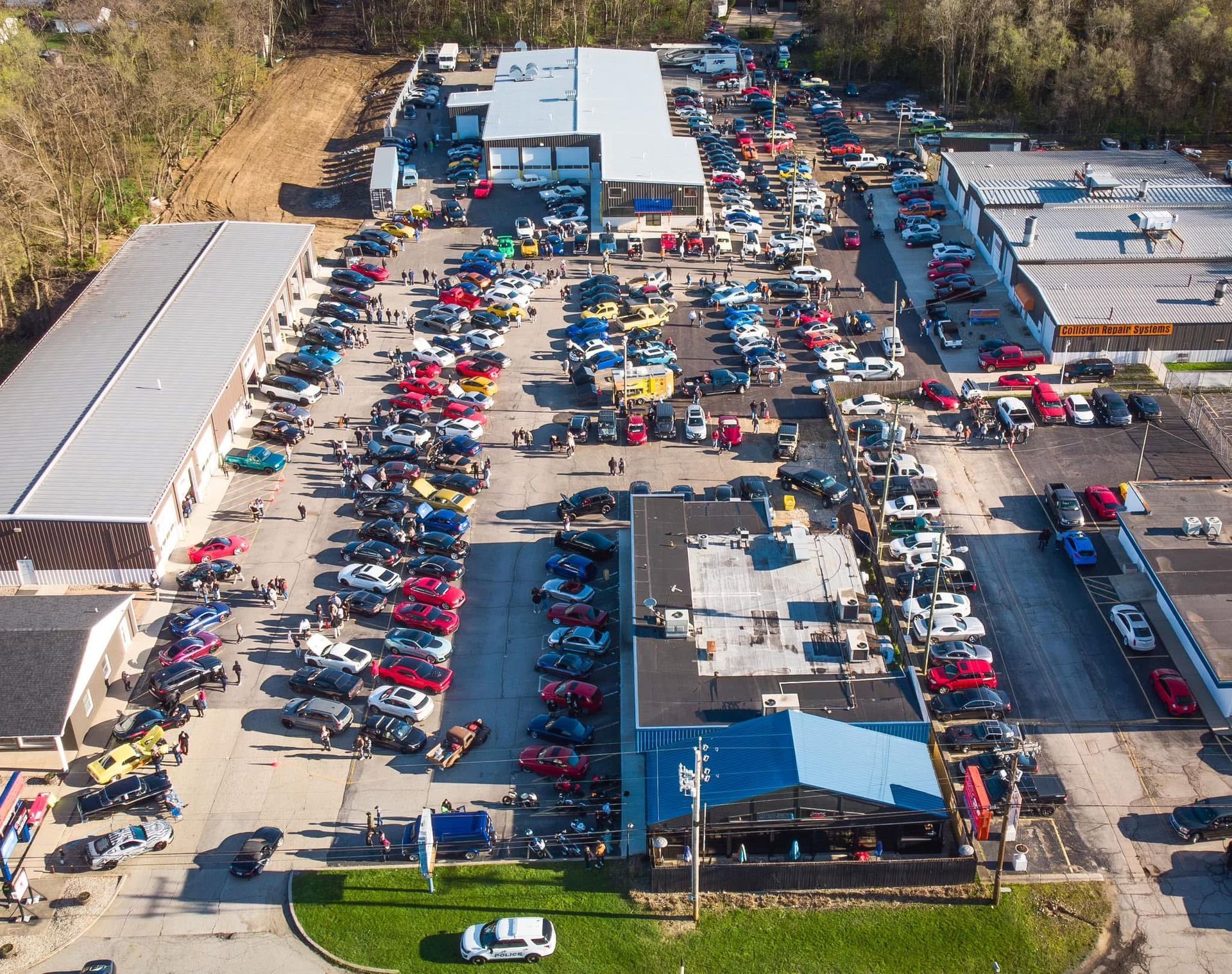 A person wearing black gloves is polishing the hood of a red car.