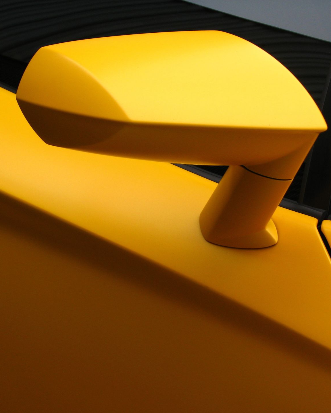 A yellow sports car is parked in a garage.