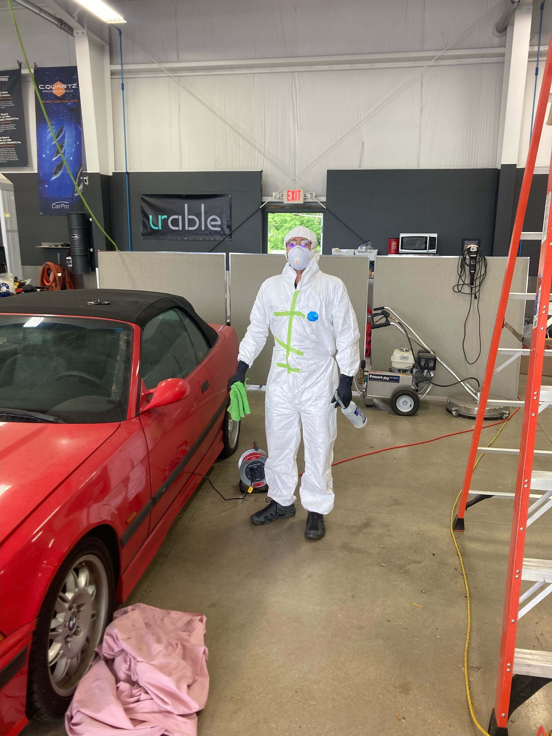 A person is cleaning the interior of a car with a vacuum cleaner.