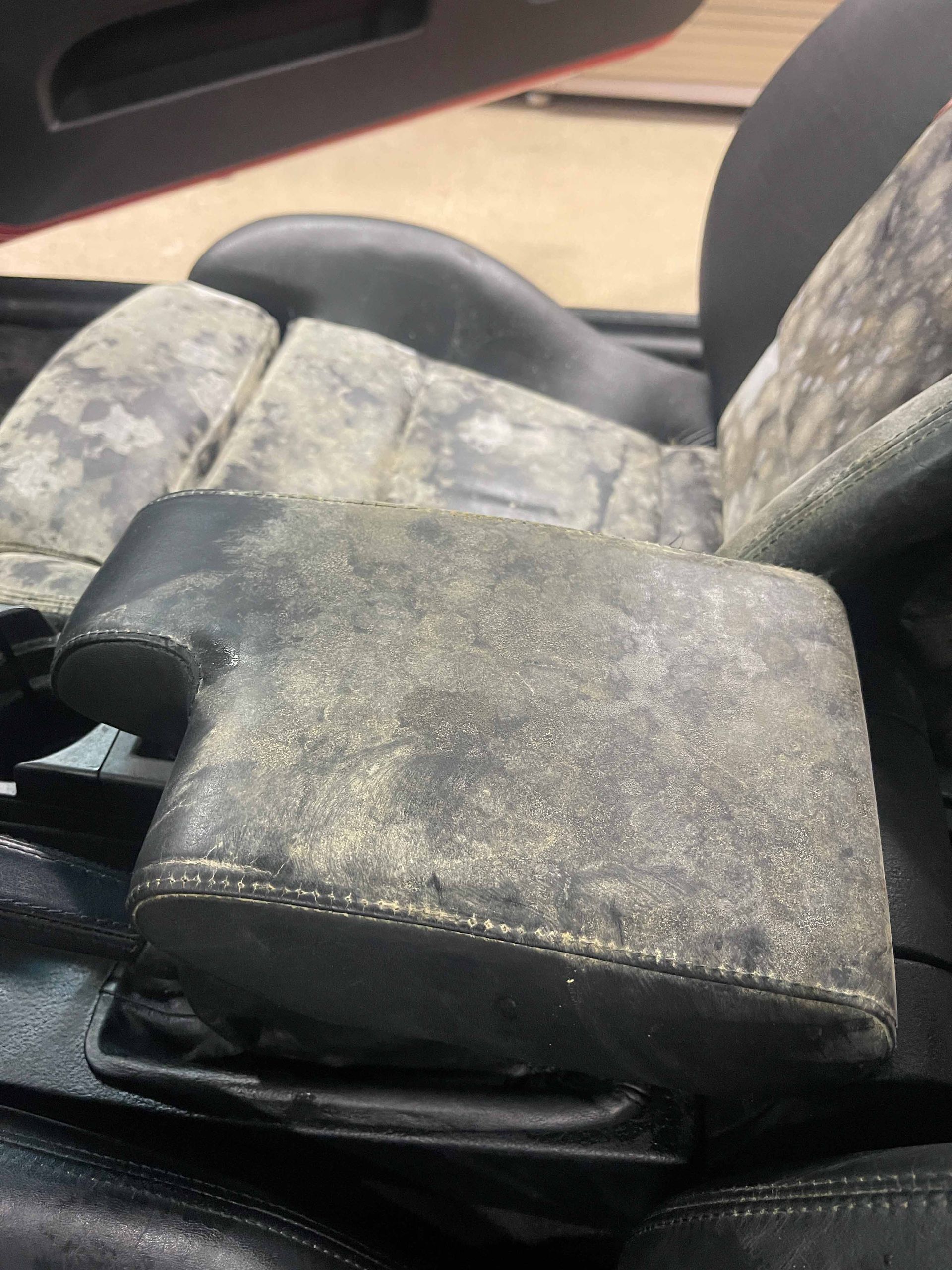 A person wearing black gloves is polishing a black car