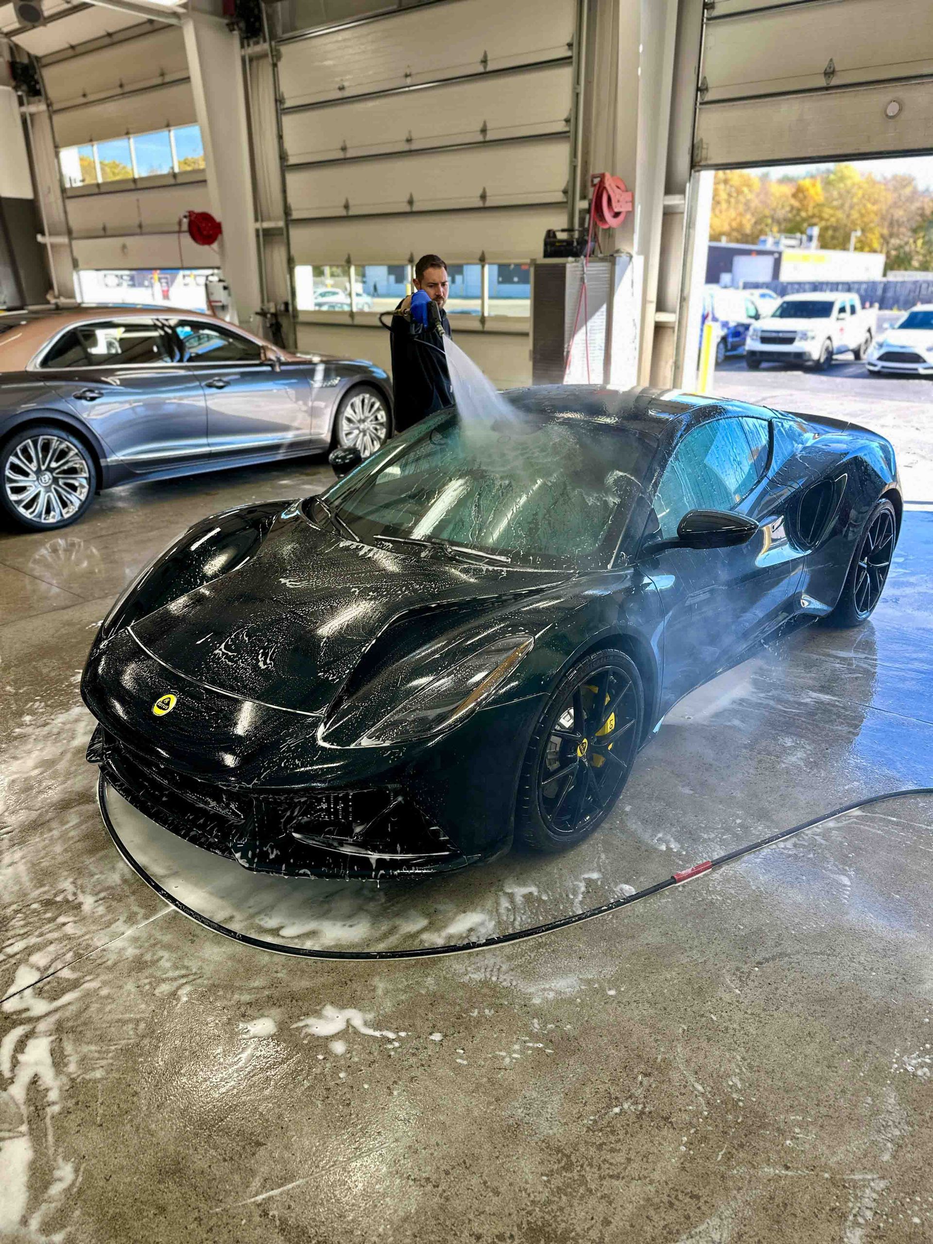 A person is cleaning the interior of a car with a vacuum cleaner.
