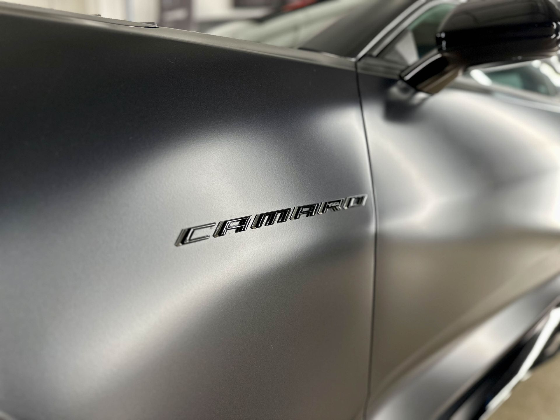 A car is being washed with foam in a garage.