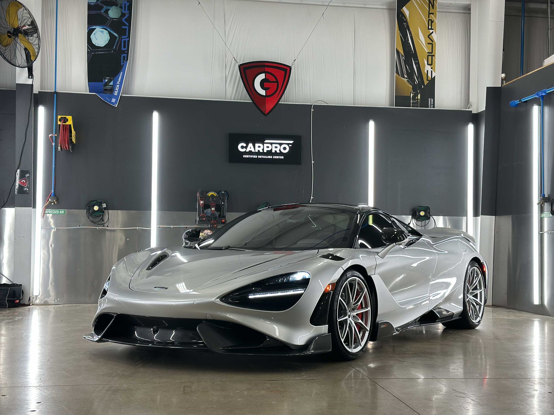 Silver McLaren 720S sports car in a detailing shop.