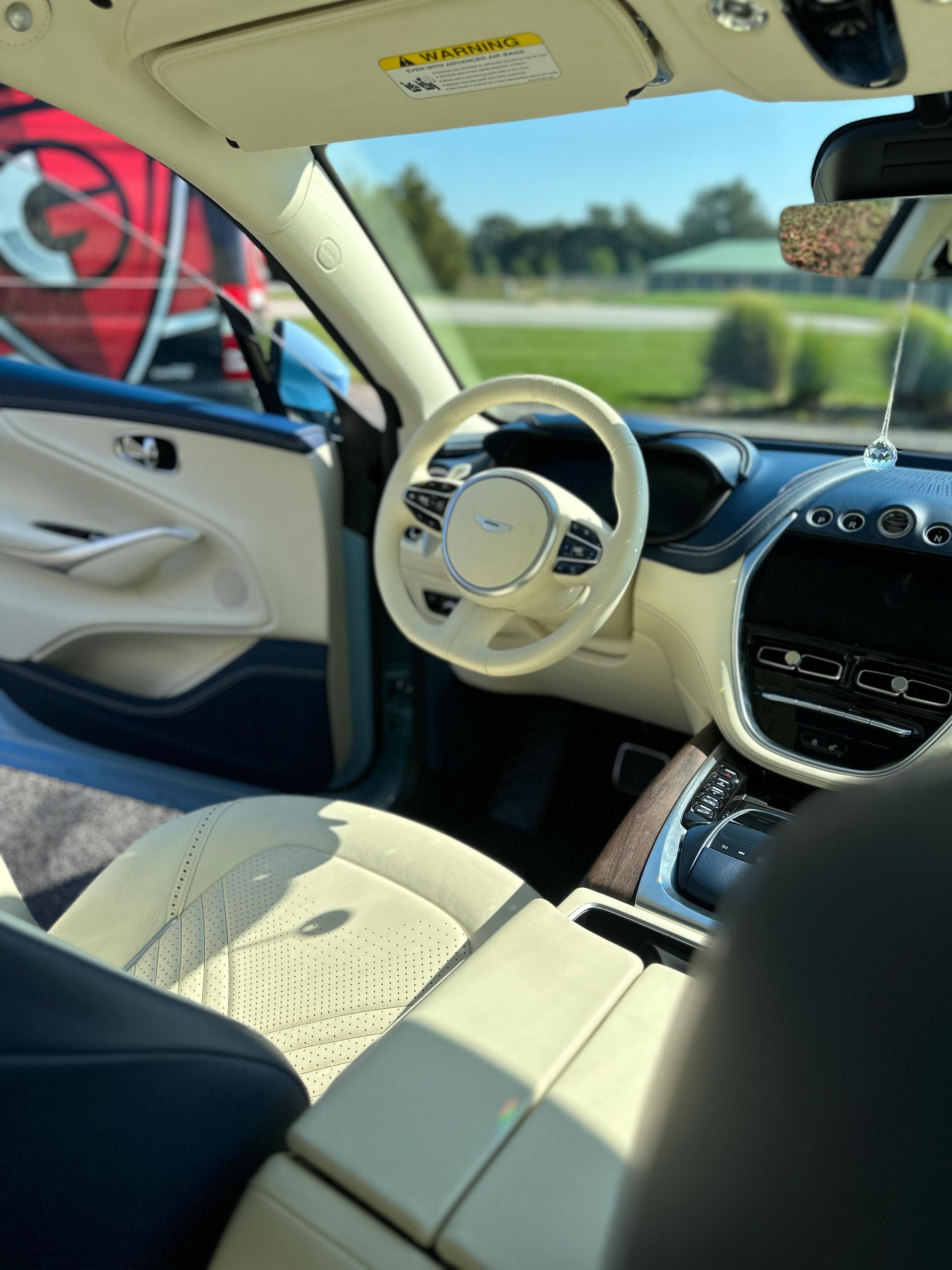 A person wearing black gloves is polishing a black car