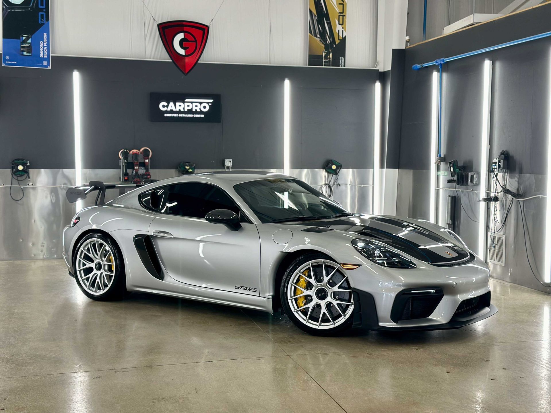 Silver Porsche sports car in a detailing shop.