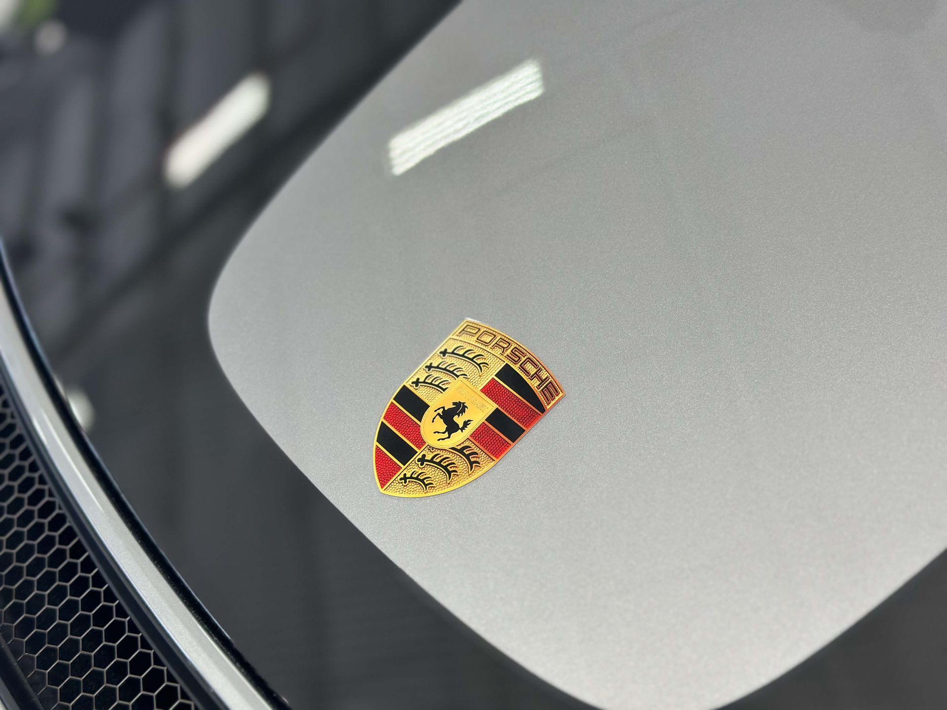 Porsche crest logo on a car's windshield.