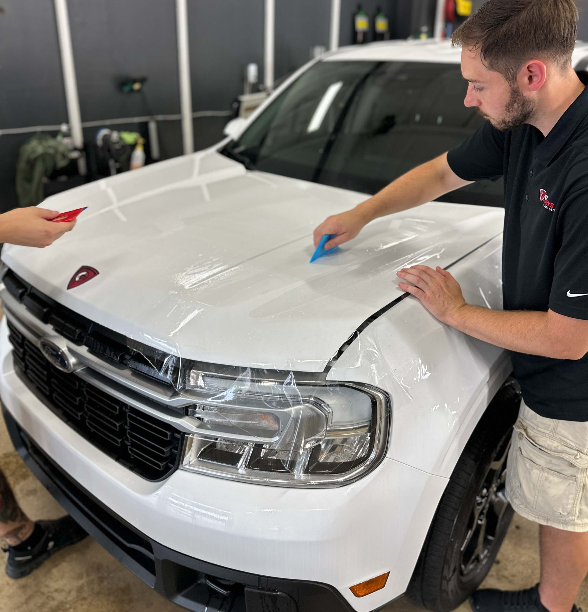 A close up of water drops on the hood of a car