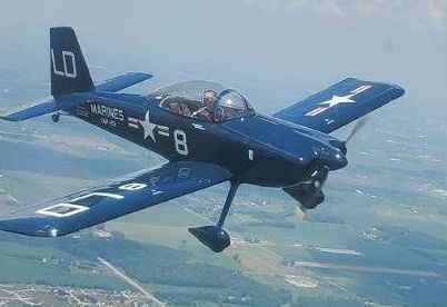 Blue and white airplane in flight, marked 