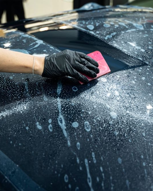 A person is cleaning the interior of a car with a vacuum cleaner.