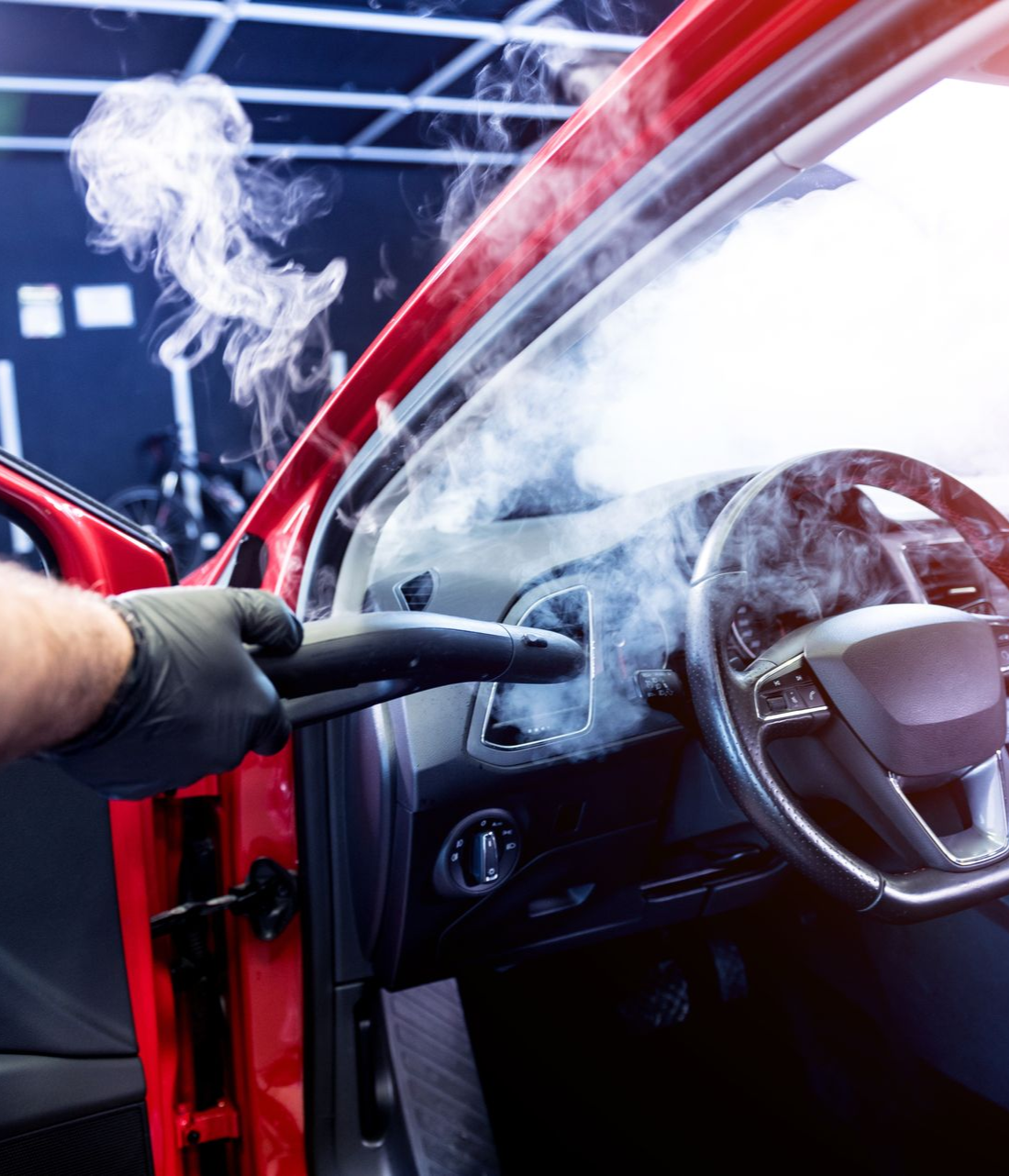 A person is cleaning the interior of a car with a vacuum cleaner.