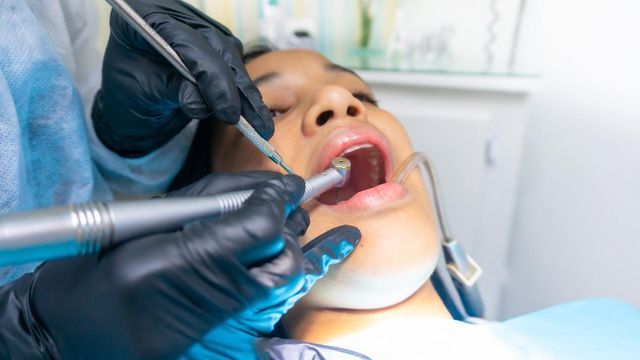 A woman is having her teeth examined by a dentist.