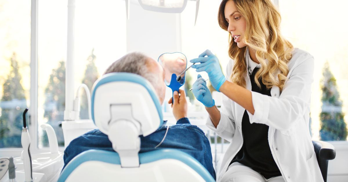 A female dentist is examining a patient 's teeth in a dental office.