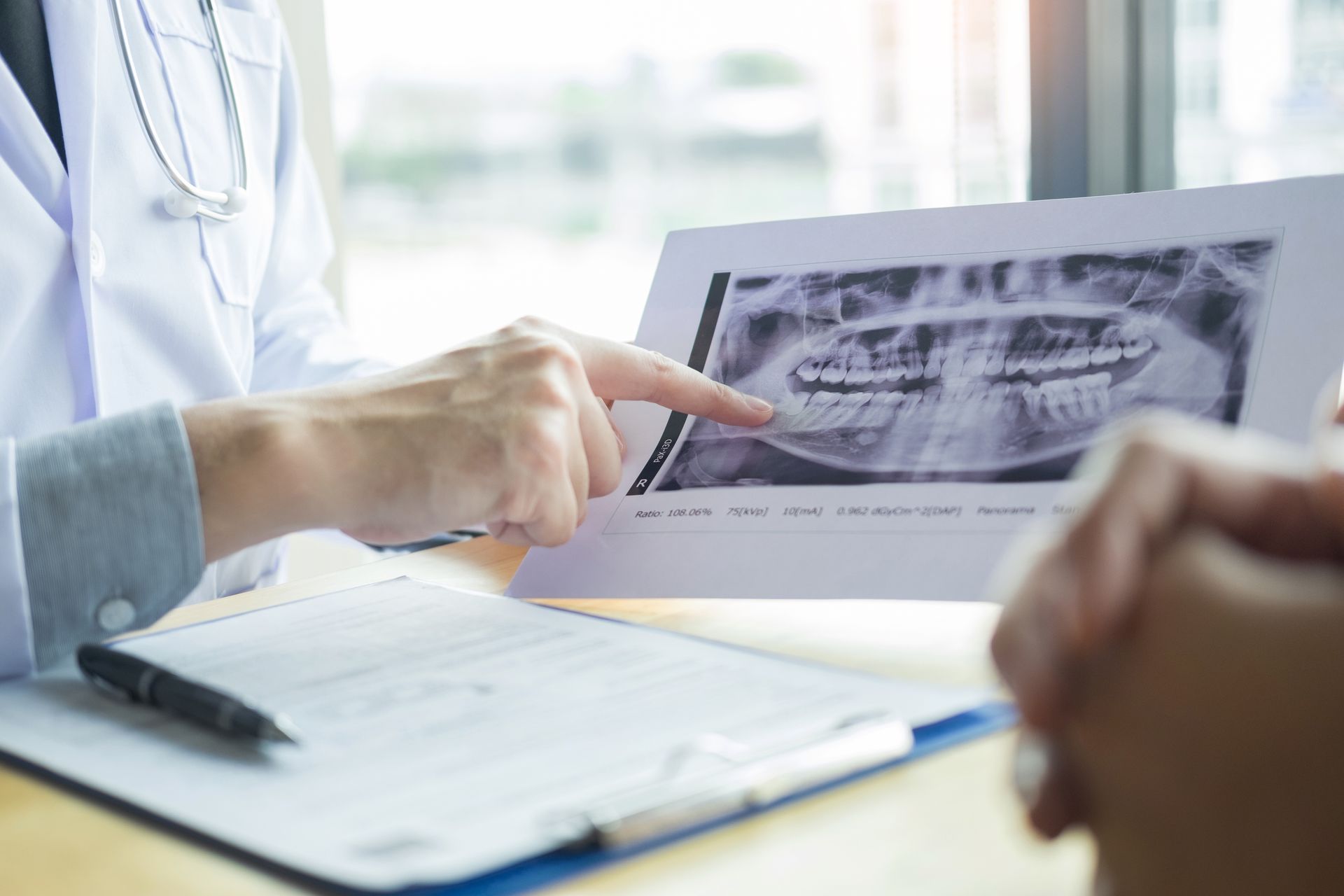 A doctor is looking at an x-ray of a patient 's teeth.