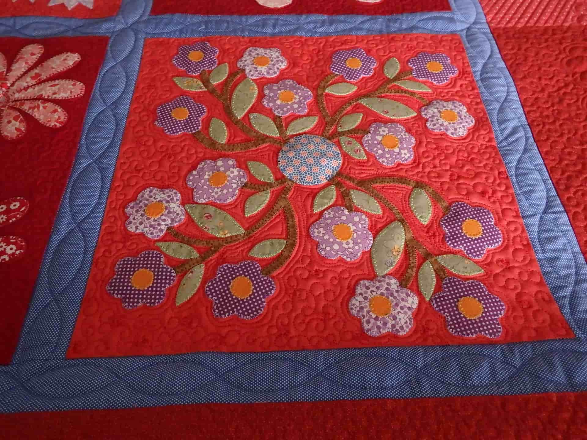 Appliquéd Floral Quilt Square on Red Background — Morning Star Quilting in Bateau Bay, NSW