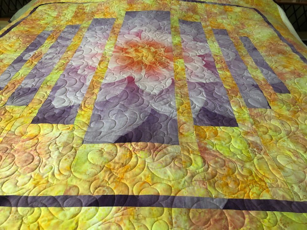Quilted Bedspread With a Large Floral Design in Yellow, Purple, and Orange — Morning Star Quilting in Bateau Bay, NSW