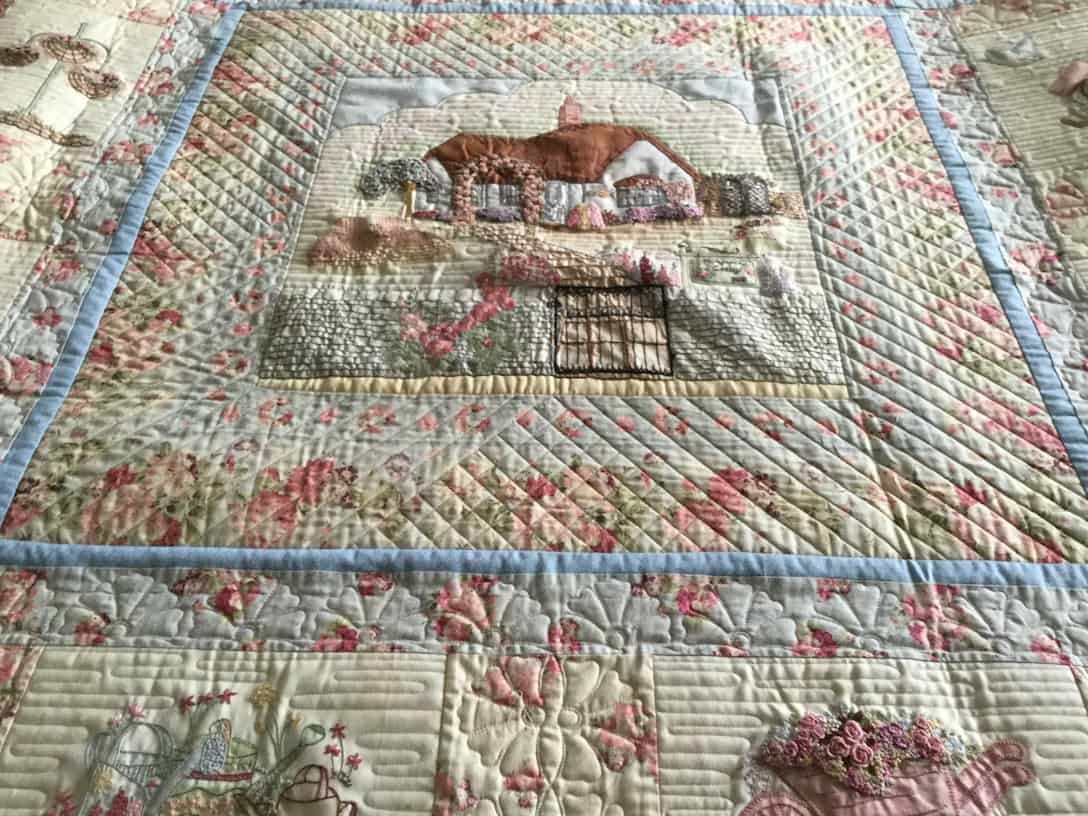 Quilted Blanket Featuring a Cottage Scene, Floral Patterns, and Light Blue Borders — Morning Star Quilting in Bateau Bay, NSW