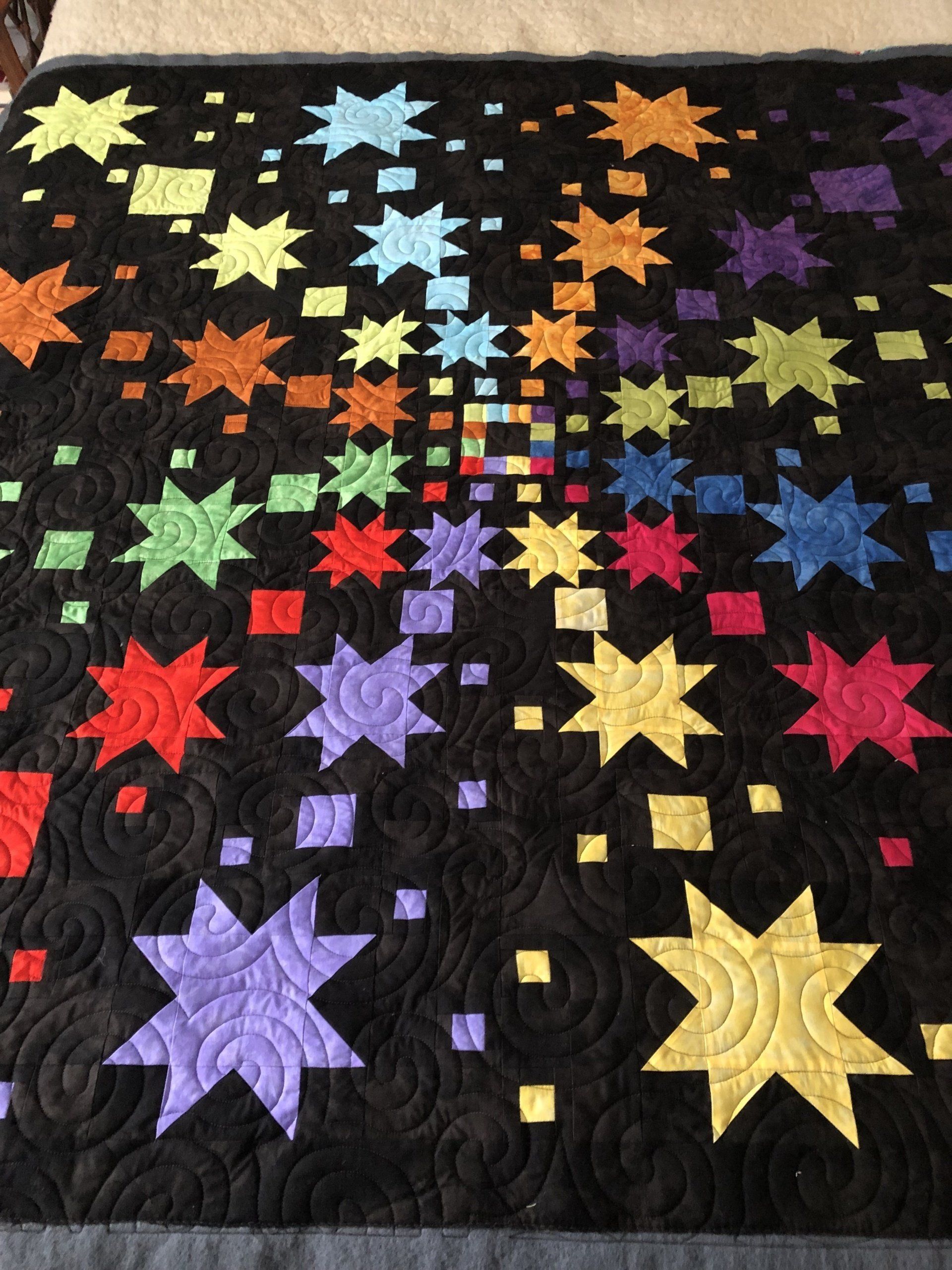Quilt With Colourful Starbursts on a Black Background; Spiral Quilting — Morning Star Quilting in Bateau Bay, NSW
