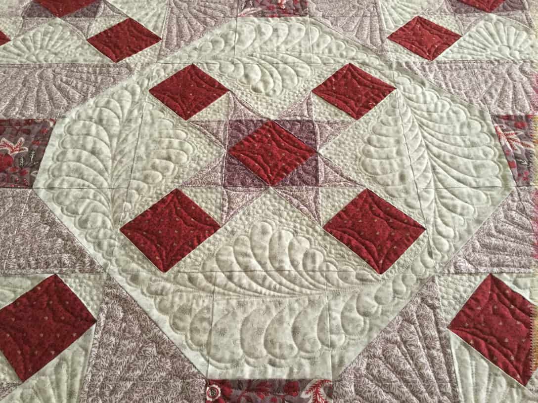 Red and White Quilt With Diamond and Feathered Patterns — Morning Star Quilting in Bateau Bay, NSW